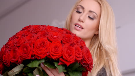 Blonde-Frau-Hält-Einen-Strauß-Frischer-Roter-Rosen