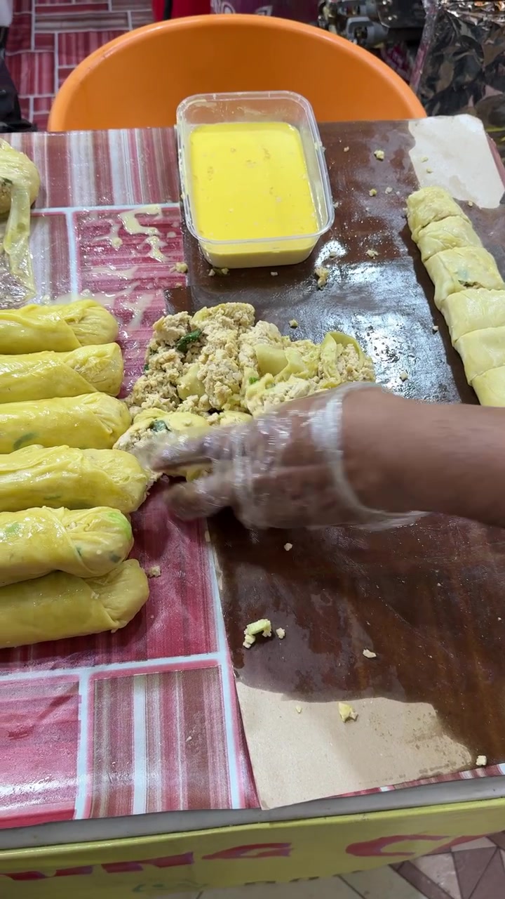 Pedagang Kaki Lima Menyiapkan Gulungan Tahu Isi
