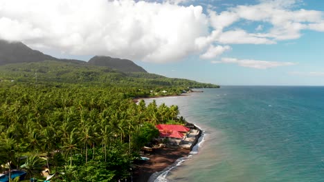 aerial drone shot over exotic island beach tropical paradise in the philippines under a blue sky and mountain range