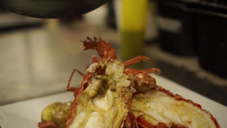 close up - putting a gravy on a cooked new zealand crayfish