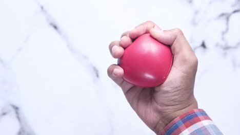 person holding a red stress ball