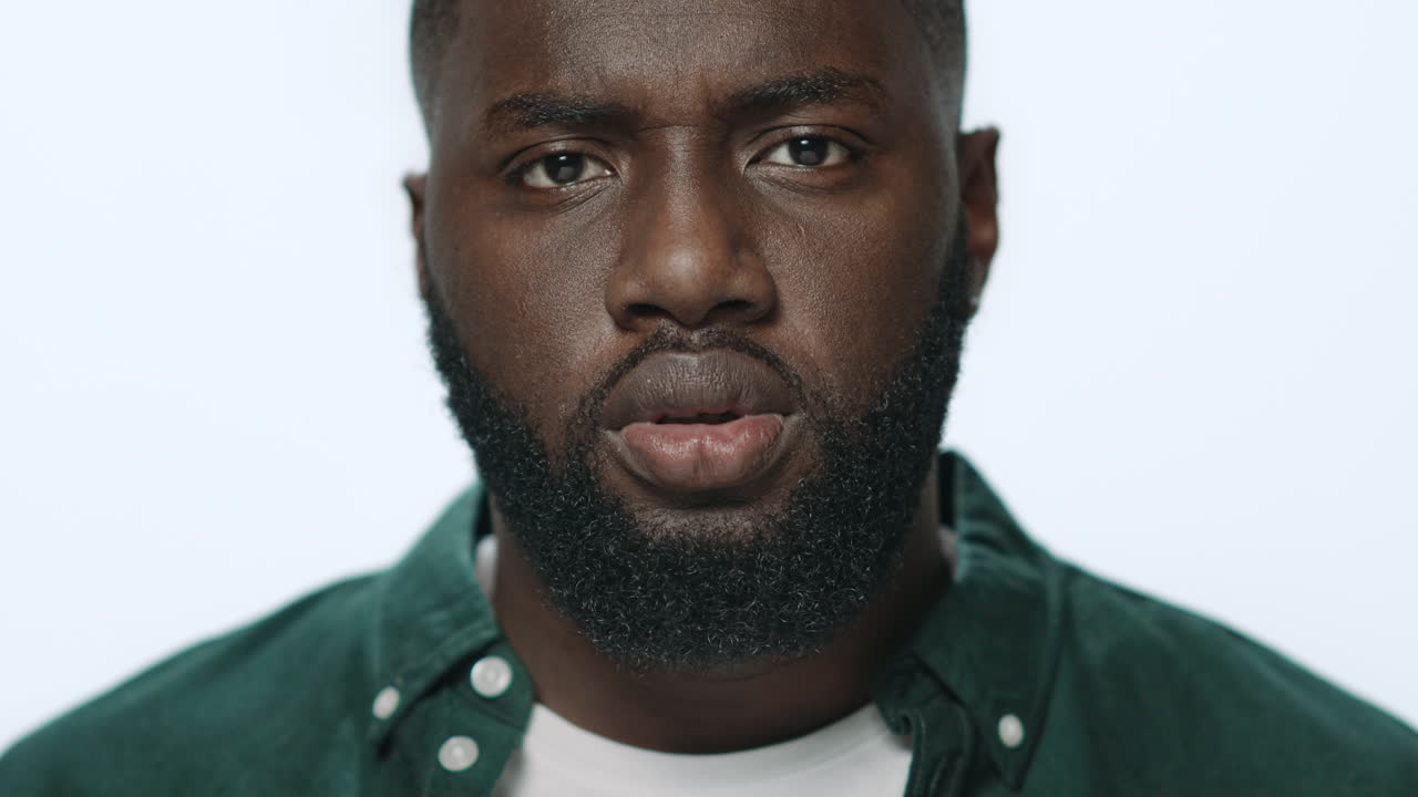 Portrait of thoughtful african american guy looking at camera in studio.