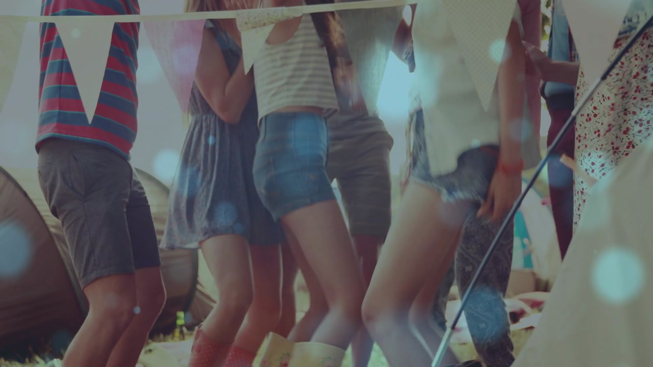 Group stepping and swaying under fest bunting on beat, celebrating with bokeh over boots