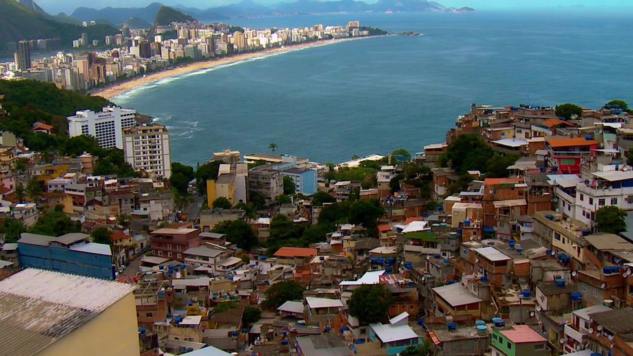 Een ongeplande favela-gemeenschap strekt zich uit langs de heuvel richting het strand in Rio de Janeiro