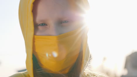 Portrait-Of-A-Girl-In-A-Yellow-Hood-And-A-Yellow-Protective-Mask