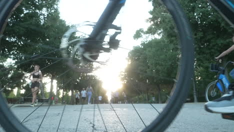 personas en bicicleta y caminando en un parque