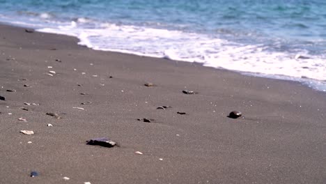 Sich-Langsam-Bewegende-Wellen,-Die-Kleine-Kieselsteine-Am-Strand-Herumschieben