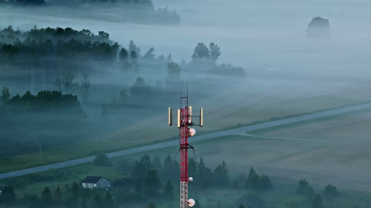 Vista aerea orbitale di una torre di telecomunicazioni 5G in un campo rurale nebbioso