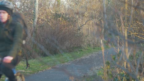 Hombre-En-Bicicleta-Por-El-Sendero-Del-Bosque-Durante-La-Hora-Dorada