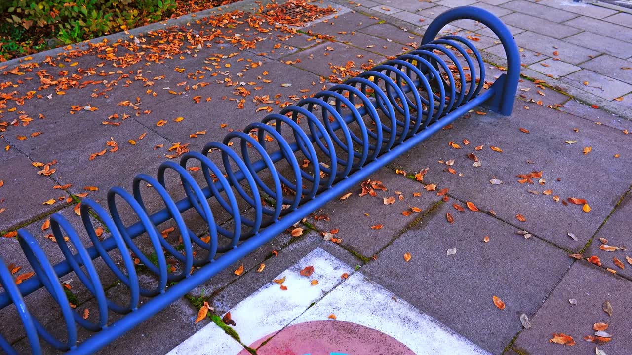 Blue bicycle parking stand near painted crossed circle sign