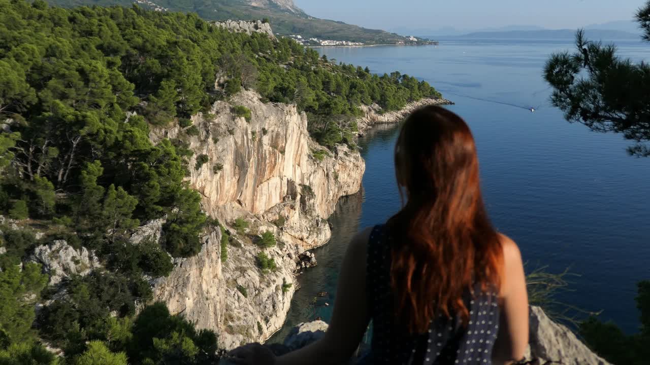 mujer mirando un futuro brillante en la cima de la montaña con vista al mar