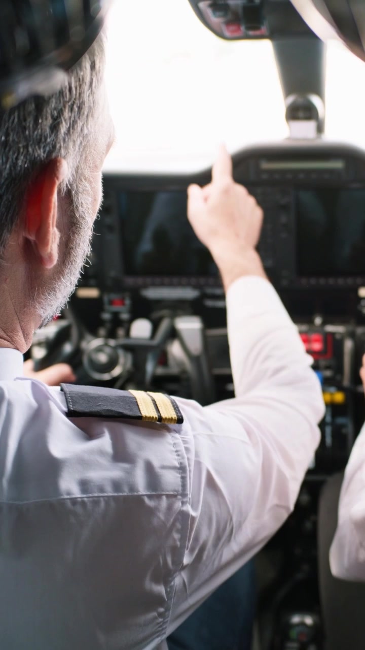 Pilota professionista che aziona i comandi dell'aereo nella cabina di pilotaggio.