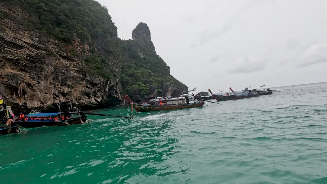 보트 들 은 높은 절벽 근처 의 푸른 물 에서 항해 한다