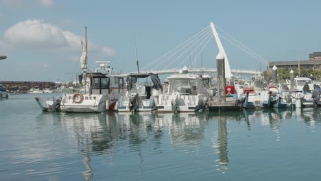 Danshui-marina-boats-with-bridge-backdrop,-Taiwan