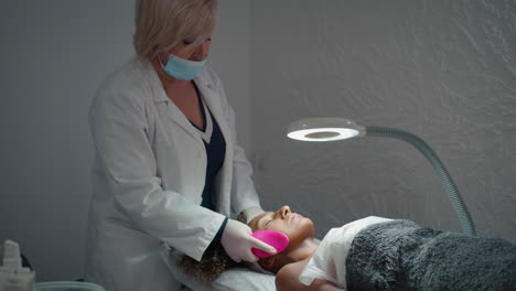 cosmetologist cleansing face skin on exfoliating procedure. woman massage client