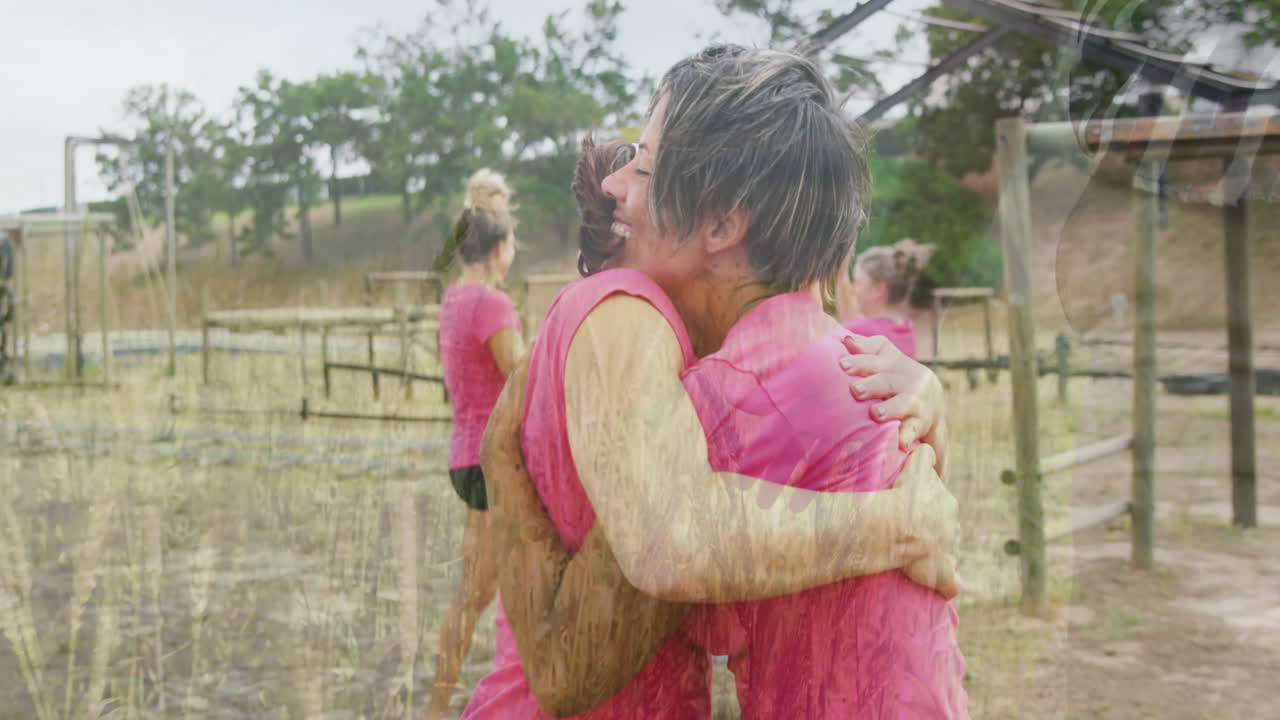 Hugging in pink shirts, women celebrating after completing team challenge outdoors