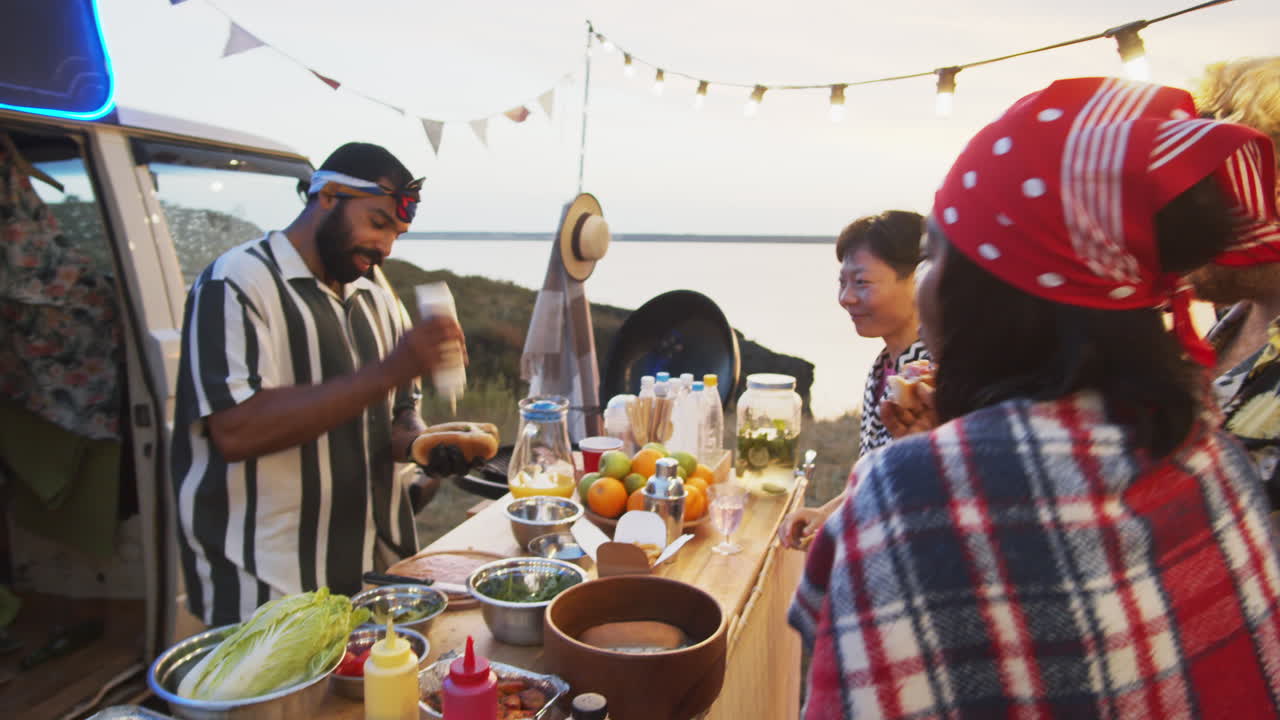 personas esperando un perrito caliente en el camión de comida en el festival de verano