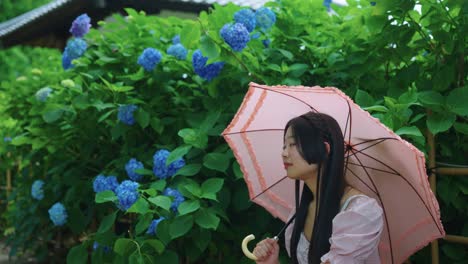 young japanese women in pink pastel colors, hydrangea garden in background