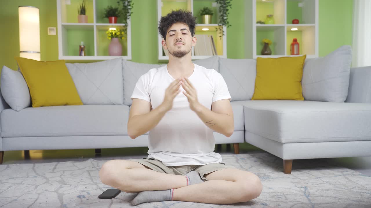 Pria muda yang sedang meditasi dan latihan pernapasan