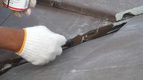 asian worker doing roof tiles installation, cutting, measuring process, close up