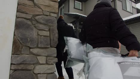 two women carrying pillows in the snow