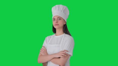 retrato de una chef profesional india de pie con las manos cruzadas pantalla verde