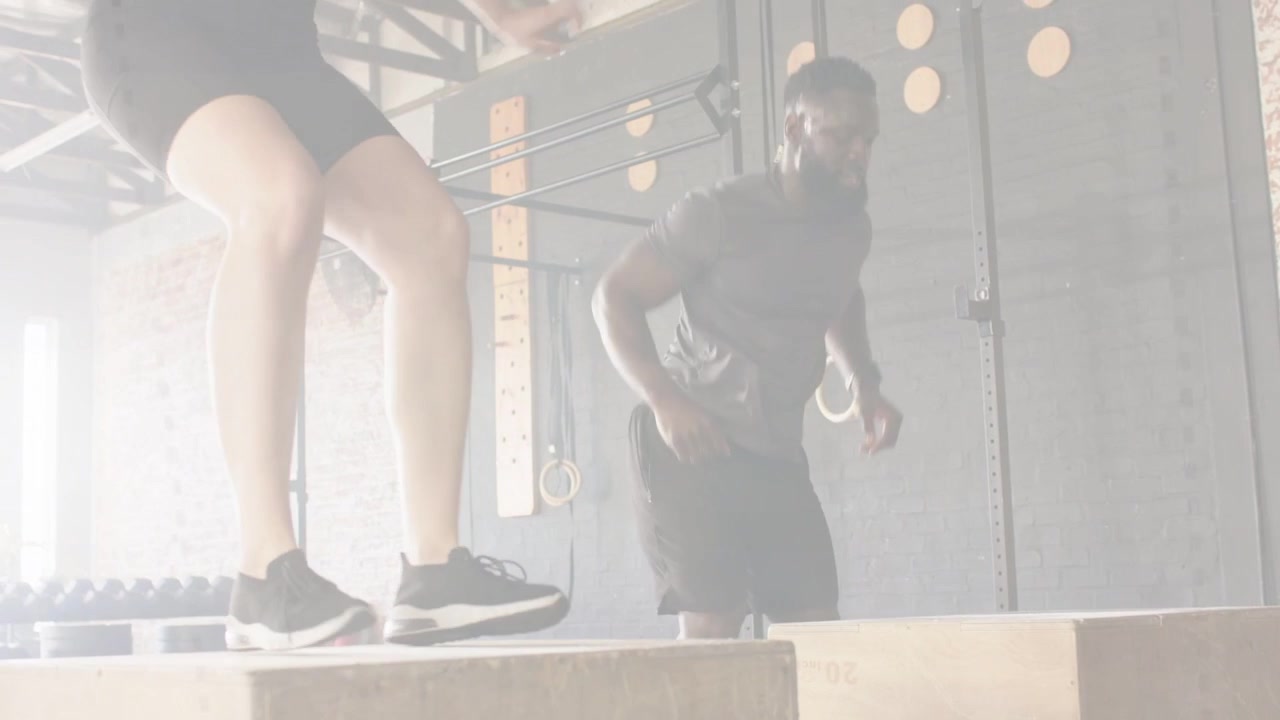 Donna e uomo iniziano uno squat basso su plyo box, sincronizzando salti esplosivi per la potenza fisica.