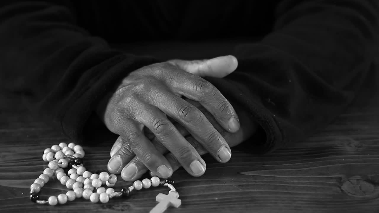 praying to God with hand's together with cross and with people black background stock video stock footage