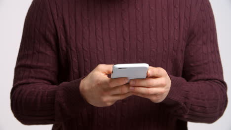 fotografía de estudio de un hombre enviando un mensaje de texto sobre un fondo blanco