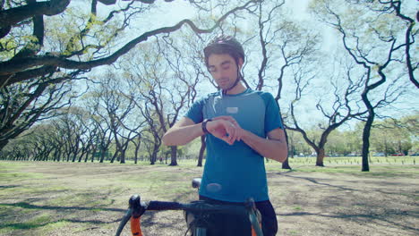 cyclist setting smart watch before bike ride outdoors