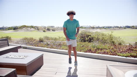 a young biracial woman is skipping rope outdoors in her backyard at home