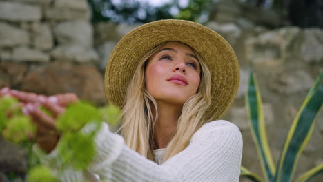 Close-up-Portrait-Of-A-Blonde-Woman-Tourist-Smelling-Green-Foliage-During-Summer