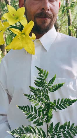 man with yellow flowers and fern