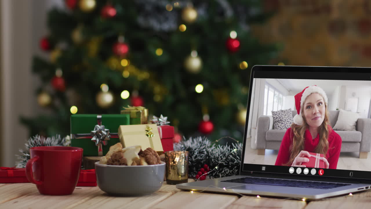 mujer caucásica feliz en videollamada en computadora portátil, con decoraciones de navidad y árbol