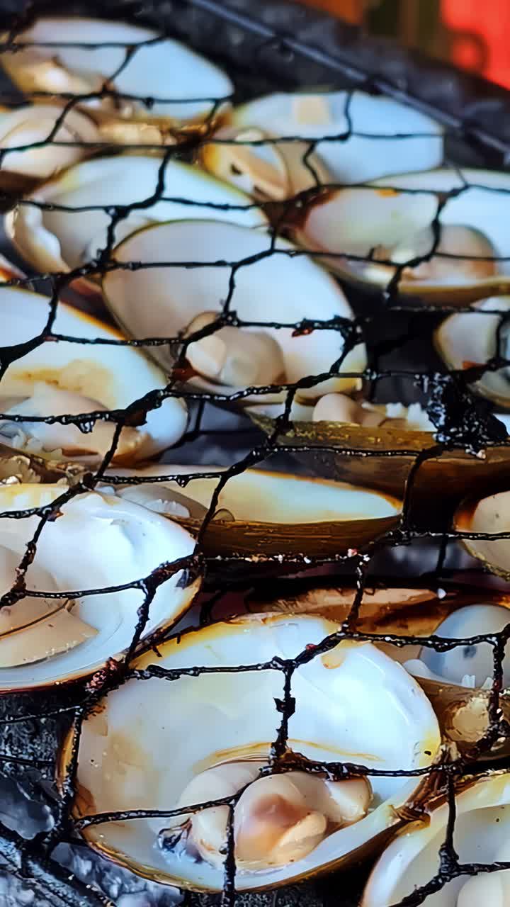 Vertical close up of oysters grilling on charcoal at Kedonganan fish market Bali Indonesia, seafood street food