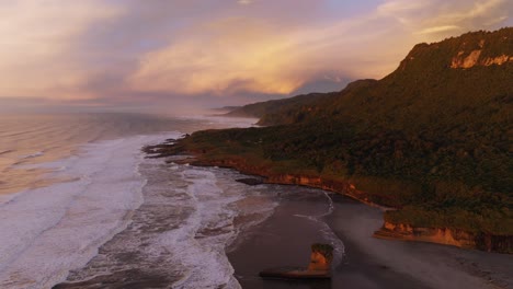 beautiful aerial view of sunset over punakaiki coastal landscape, beach and rolling waves of ocean on the west coast of south island, new zealand aotearoa