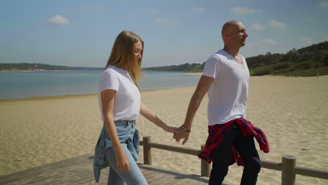 smiling couple walking on beach together