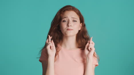 redheaded girl looking at camera on turquoise background.