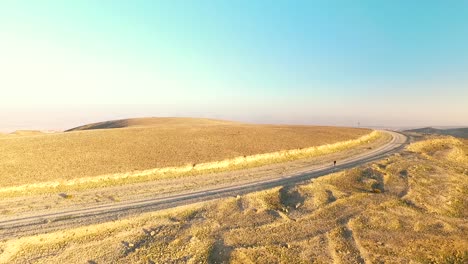 man walks alone in a rocky yellow desert