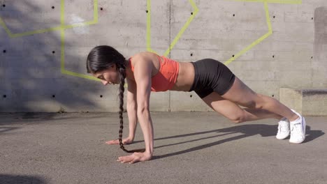 Young-woman-doing-plank-with-knee-in-and-out-exercise,-Side-View