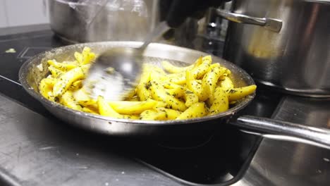 chef stirring sliced fruits in saucepan