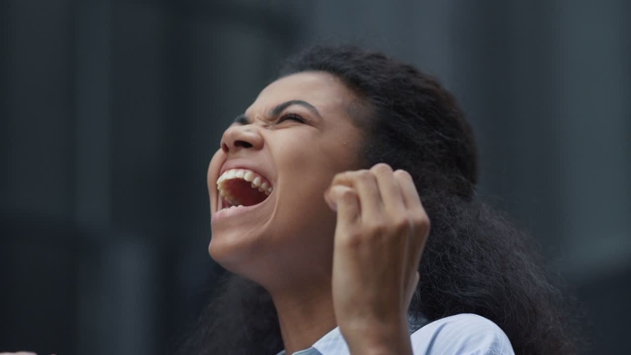 mujer feliz celebrando el éxito de pie en el edificio de oficinas solo primer plano