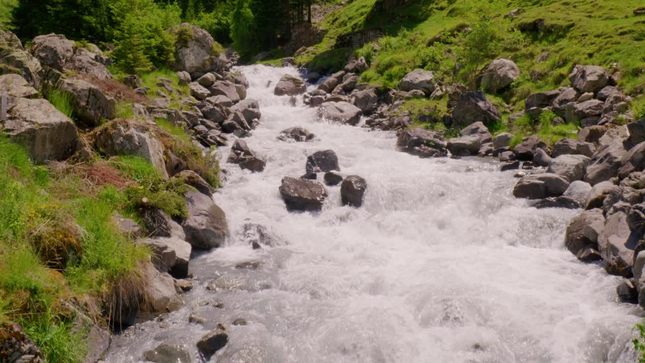 Scatto che rivela le rapide nel fiume Schächen con lo Staubifall in lontananza.