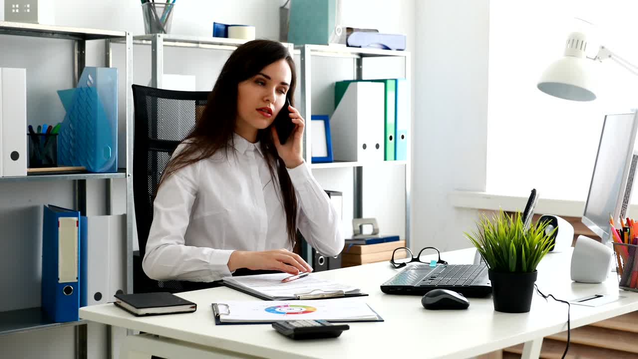 mujer de negocios hablando en teléfono inteligente y trabajando en una oficina moderna