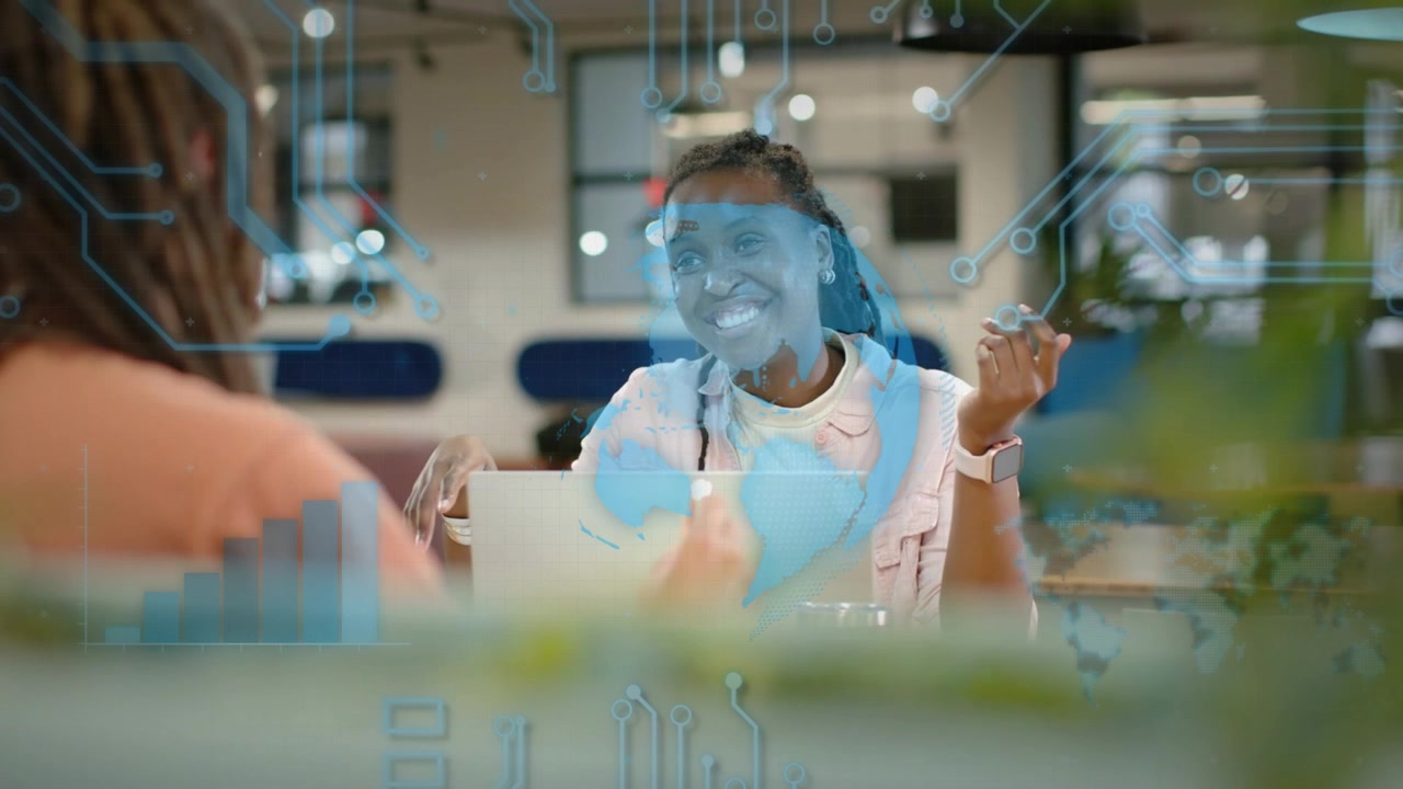 Woman at laptop tapping and activating blue tech overlay map for business demo guiding colleague