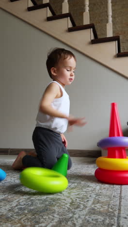 small cute boy playing with colorful toy. adorable happy child having activity. vertical video.