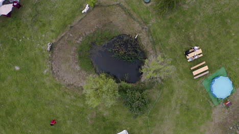 small pond in a garden with wedding preparations around,overhead view