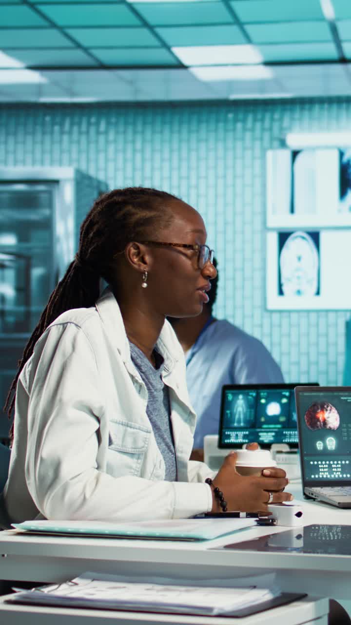 African American Doctor Analyzing Brain Scans on Laptop in Medical Lab