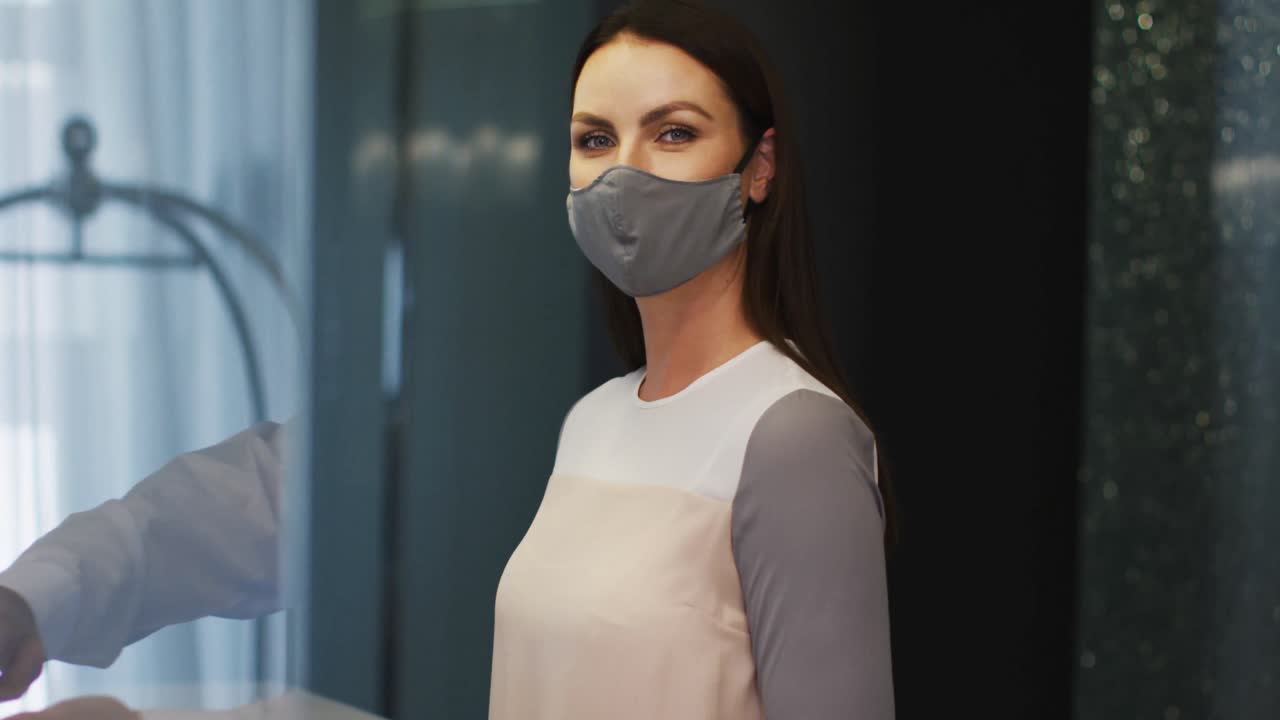 mujer caucásica con máscara de cara gris mirando a la cámara y sonriendo