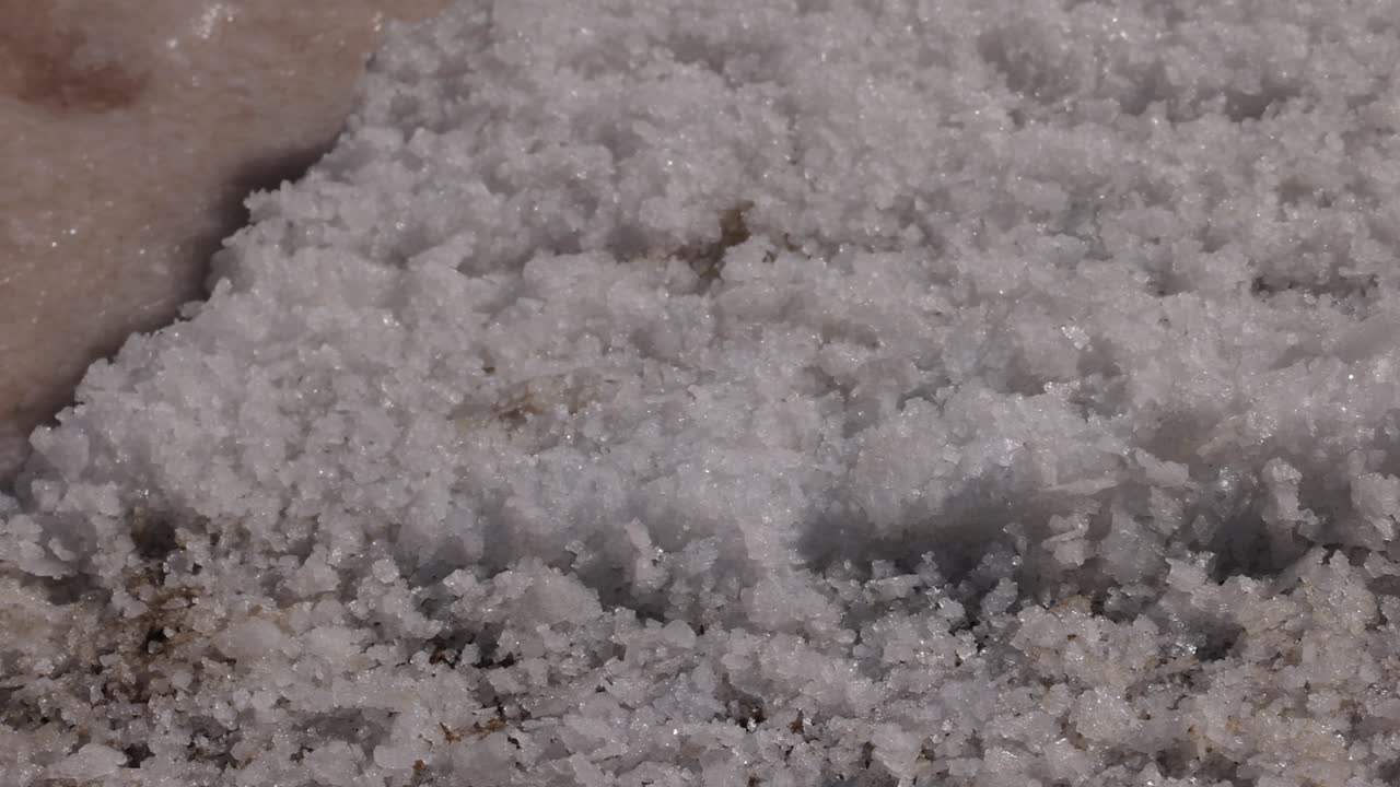 Nærbillede af saltindhøstningsprocessen i saltbassiner i Portugal. Salttørring